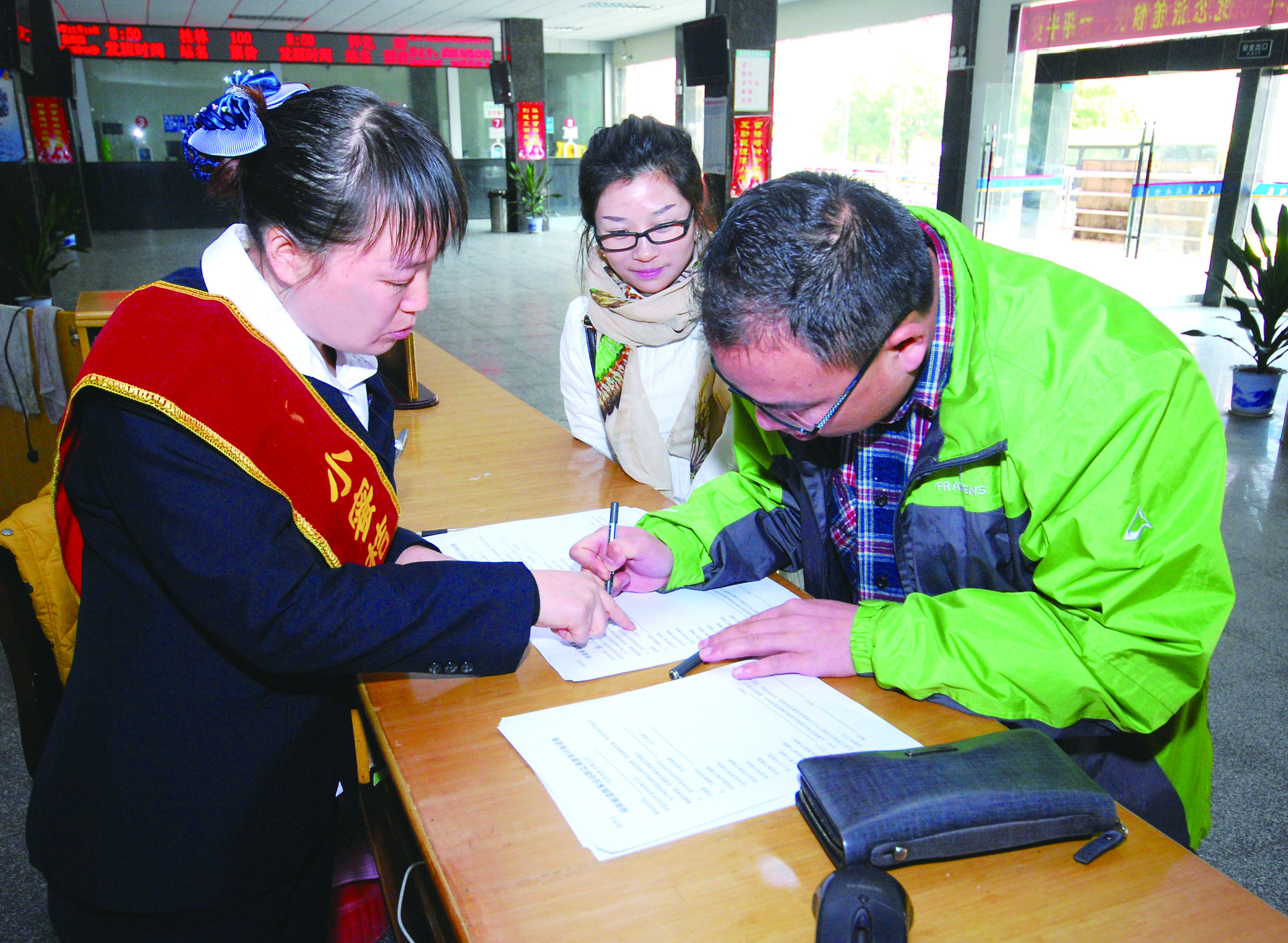 圖為洞口汽車總站站務(wù)人員在熱心為旅客服務(wù)。